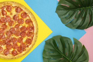 Yaz kompozisyon Pizza pepperoni yapılmış, Renkli arka plan üzerinde Tropikal Yaprak Monstera ile Straw Hat. Kopya alanı ile Yaz Tatil Gıda Kavramı. Üst te. Düz Lay