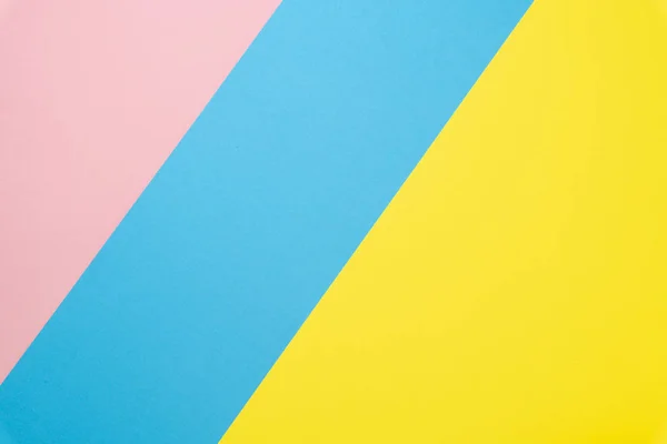 Abstraktní geometrické pozadí papíru. Modré, růžové a žluté barevné trendy. Rovně ležet. Pohled shora — Stock fotografie