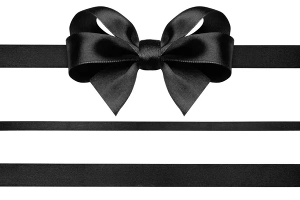 Чорна стрічка з подарунковим бантом ізольована на білому. Різдвяний святковий лук чорної блискучої атласної стрічки та горизонтальні лінії стрічки — стокове фото