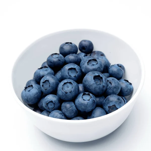 Fresh blueberries in bowl isolated on white. Top view. — Stock Photo, Image