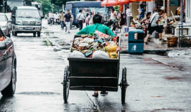 Çin 'de çöp. Çöpçü bir çöp sepeti çeker