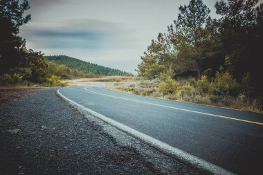 Işıklar gece ay tarafından aydınlatılmış bir dağ yolda asfalt üzerinde ufuk, bir dönüş yapma, ışığın bir iz bırakarak bir araba üzerinde yükselmeye başlar. Uzun pozlama kırık dağ yolu