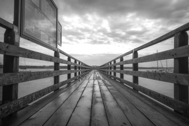 Siyah ve beyaz deniz suyu üzerinde eski İskelesi ile minimalist güzel sanatlar. Uzun pozlama nedeniyle yumuşak odak