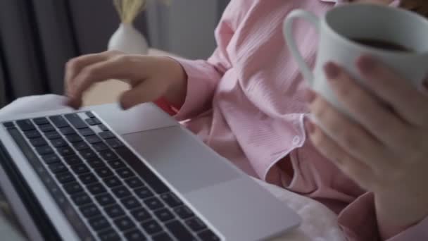 Smiling freelancer with laptop and notepad in bed — Stock Video