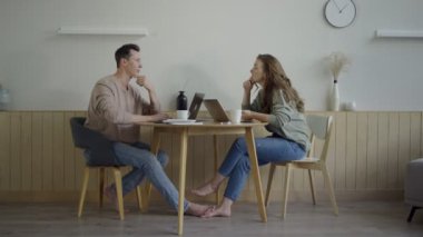 Laptoplarla çalışan modern bir çift. Masada projeyi tartışan zeki genç çift.