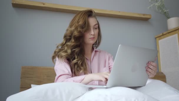 Female with laptop on bed in morning time