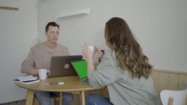 Laptoplarla çalışan modern bir çift. Masada projeyi tartışan zeki genç çift.