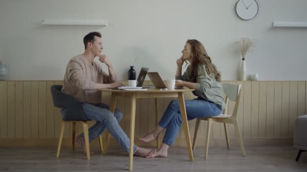 Moderne par arbejder med bærbare computere. Smart ungt par diskuterer projekt ved skrivebordet – Stock-video