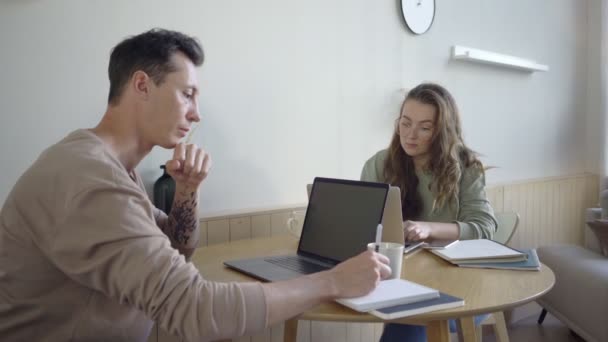 Casal moderno trabalhando com laptops. Casal jovem inteligente discutindo projeto na mesa — Vídeo de Stock