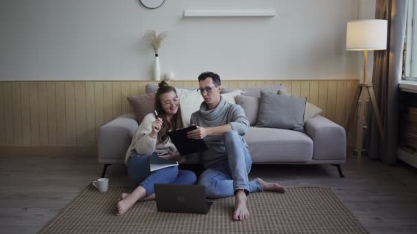 Couple inspiré discuter des plans de projet. Jeunes pigistes avec gadget et bloc-notes. — Video