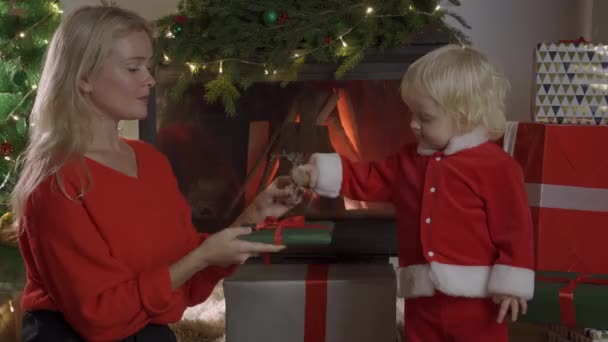 Férias e conceito de família - mãe feliz e filha com caixa de presente sobre quarto com fundo de árvore de Natal — Vídeo de Stock