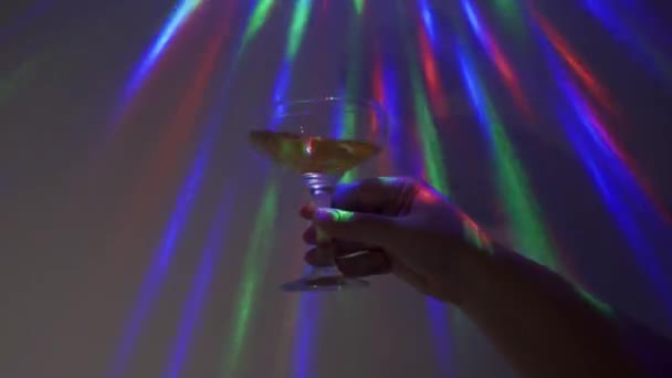 Een vrouw met een champagneglas op abstracte achtergrond. Feest. Partijconcept. — Stockvideo