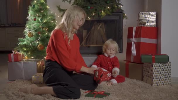 Vakantie en familie concept - gelukkige moeder en dochter met geschenkdoos over kamer met kerstboom achtergrond — Stockvideo