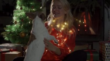 Noel süslemeleri içinde köpekli mutlu kız. 