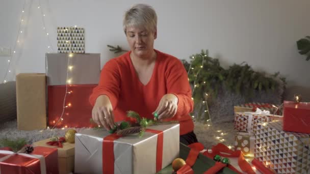 Kvinna inslagning julklapp vid bordet. — Stockvideo