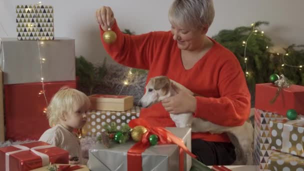 Νεαρή μητέρα δένοντας τόξο τα Χριστούγεννα δώρο, ενώ η κόρη της βοηθώντας την ετοιμάζονται για διακοπές στο σπίτι — Αρχείο Βίντεο