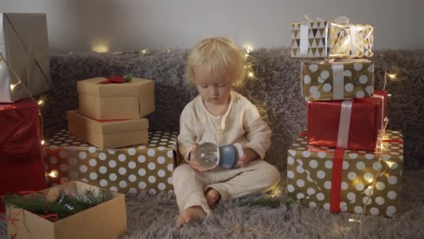 Szczęśliwa mała uśmiechnięta dziewczynka z pudełkiem świątecznym. Boże Narodzenie dziecko szczęśliwy prezenty prezenty. — Wideo stockowe