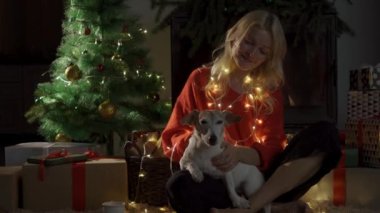 Noel süslemeleri içinde köpekli mutlu kız. 