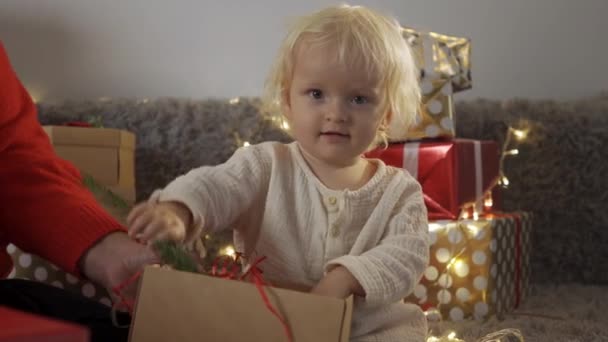 Szczęśliwa mała uśmiechnięta dziewczynka z pudełkiem świątecznym. Boże Narodzenie dziecko szczęśliwy prezenty prezenty. — Wideo stockowe