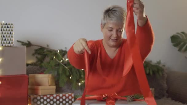 Mujer envolviendo regalo de Navidad en la mesa. — Vídeo de stock