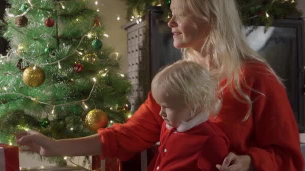 Happy family mother and baby near Christmas tree in the holiday night. — Stock Video