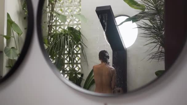 Joven morena tomando una ducha tropical. Ducha en la villa privada. — Vídeos de Stock