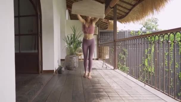 Mujer yogui desplegar estera de yoga. Practicar clases de yoga, hacer ejercicio, en interiores. Bienestar, concepto de bienestar. — Vídeos de Stock