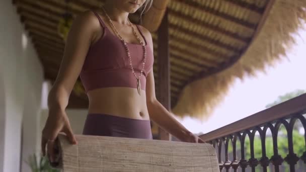 穿着运动服的年轻女子在家里拿着瑜伽垫. — 图库视频影像