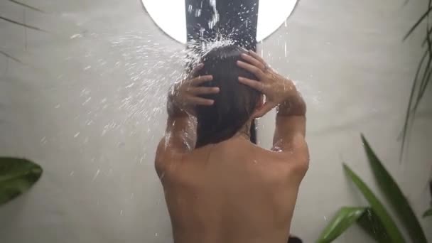 Junge brünette Frau unter der tropischen Dusche. Dusche in der privaten Villa. — Stockvideo