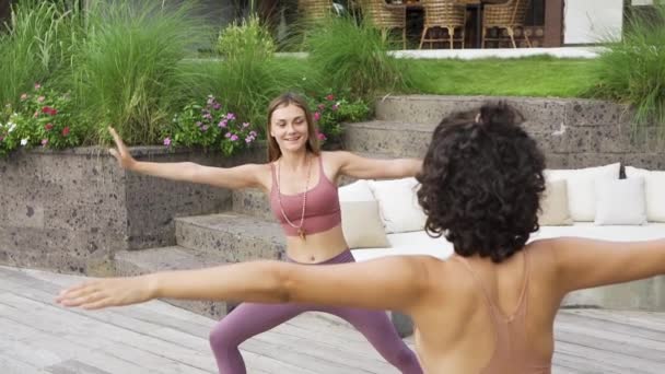 Glückliche gesunde zwei Frauen, die am Wochenendmorgen zu Hause trainieren und Yoga praktizieren. Gesundheits-, Sport- und Lifestylekonzept. — Stockvideo