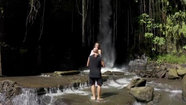 Paar genießt Pool und entspannen am Fuße des großen Wasserfalls — Stockvideo