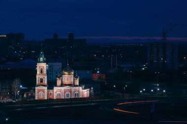 Znamensky tapınağının altın kubbeleri, 17 Nisan 2018'de Rusya'nın Barnaul şehrinin gece arka planında parlıyor. Yayla parkının yüksekliğinden şehir manzarası. Işıklar ile güzel şehir manzarası.