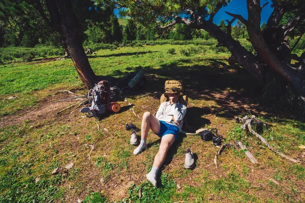 Traveler Resting Meadow Conifer Tree Hike Man Large Backpack Relax — Stock Photo, Image