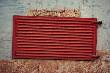 Mor tuğla duvarda kırmızı metal kapak. Grunge. Beton. Eski metal pil.