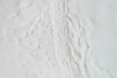 Temiz beyaz karda ayakkabı izleri. Kar akıntısı üzerinde botların izini. Karlı patikanın dokulu kış arka planı. Kar kopya alanı ile yol kaplı. Soyut minimalist karlı hava dokusu.