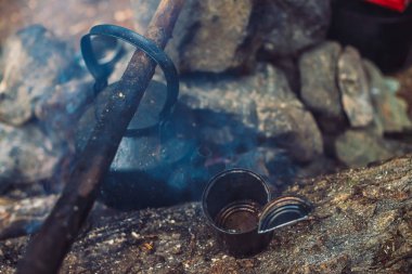 Büyük yakacak odun su ısıtıcısı ile söndürüldü şenlik ateşi. Soyu tükenmiş şenlik ateşi yakın çekim. Alacakaranlıkta terk edilmiş kamp. Evsizlerin orman meskeni. Ateş yok. Alacakaranlıkta aktif açık hava eğlencesi. Doğada temiz hava.
