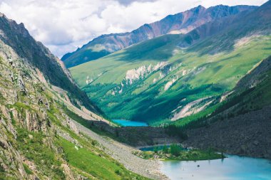 Dağlık vadideki muhteşem üç dağ gölü. Temiz gök mavisi su yüzeyi. Zengin bitki örtüsü ve kozalaklı ormanı olan dev kayalar ve dağlar. Görkemli doğanın atmosferik yeşil manzarası