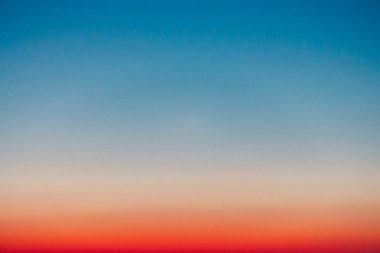 Şafak öncesi berrak gökyüzü kırmızı ufuk ve mavi atmosferile. Şafak gökyüzünün pürüzsüz turuncu mavi degradesi. Günün başlangıcının arka planı. Cennet sabahın erken saatlerinde kopya alanı ile. Gün batımı, gün doğumu arka planı.