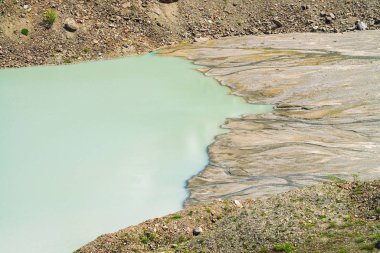 Dağlarda göl ve bataklık birleşmesi. Akarsular bataklıktan göle akar. Dağlardan birçok dere akar. Eski turkuaz rengilok su. Altay doğasının sıra dışı dokulu manzarası.