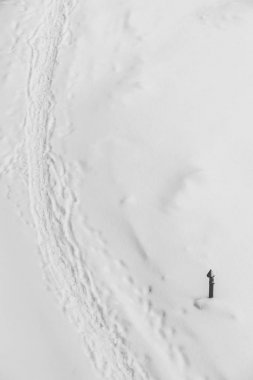 Beyaz karda ayakkabı izleri. Kar akıntısı üzerinde botların izini. Karlı patikanın dokulu kış arka planı. Kar kopya alanı ile mahzen kaplı. Soyut minimalist karlı hava dokusu. Karda boru.