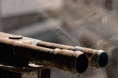 Yansımalı cam arka plan üzerinde bakır borular.