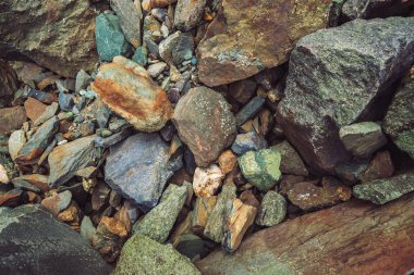 Çok renkli kaya akıntısı. Gevşek kaya yakın. Doğada rastgele dağılmış taşlar. Yosun ve likenler ile dağlık kayalar Inanılmaz ayrıntılı arka plan. Dağlık arazinin doğal dokusu.