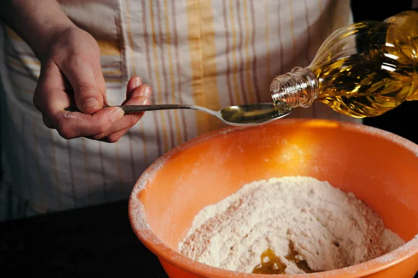 Dişi el un ile bir kase ye ayçiçek yağı dökün. Testin hazırlanması. Bir damla yağ. Güzel.