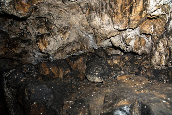 View inside a deep cave. Wet stone wall.