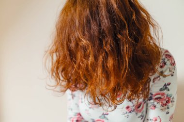 Güzel, sağlıklı, uzun, kıvırcık, kına ile boyanmış kızıl saç. Profesyonel saç bakımı.