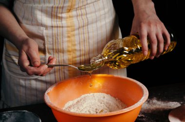 Dişi el un ile bir kase ye ayçiçek yağı dökün. Testin hazırlanması. Bir damla yağ. Güzel.