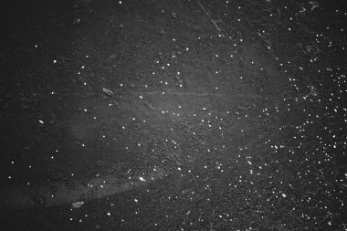 Kirli siyah duvar yakın çekim. Boya beyaz spreyler ile monokrom arka plan. Beyaz lekeler ile koyu beton duvar siyah beyaz doku. Gri tonlanına boyanmış zemin. Peelingli boya. Çırpma sıva.