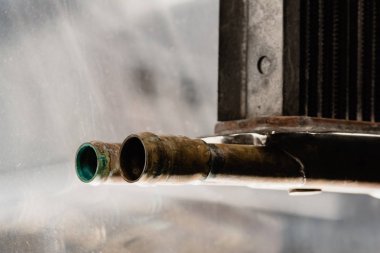 Yansımalı cam arka plan üzerinde bakır borular.