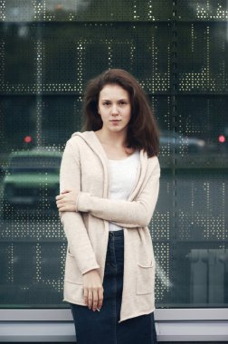 Mağaza arka plan yansıtıcı pencerede vanilya rengi ve mavi denim etek bluz yanak üzerinde köstebek ile Moda kız. İş kadını mesafeye bakıyor ve bekliyor. Kadın dalgın görünüm.
