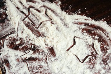 Tabloya saçılmış un üzerine boyanmış yıldızlar yakın.